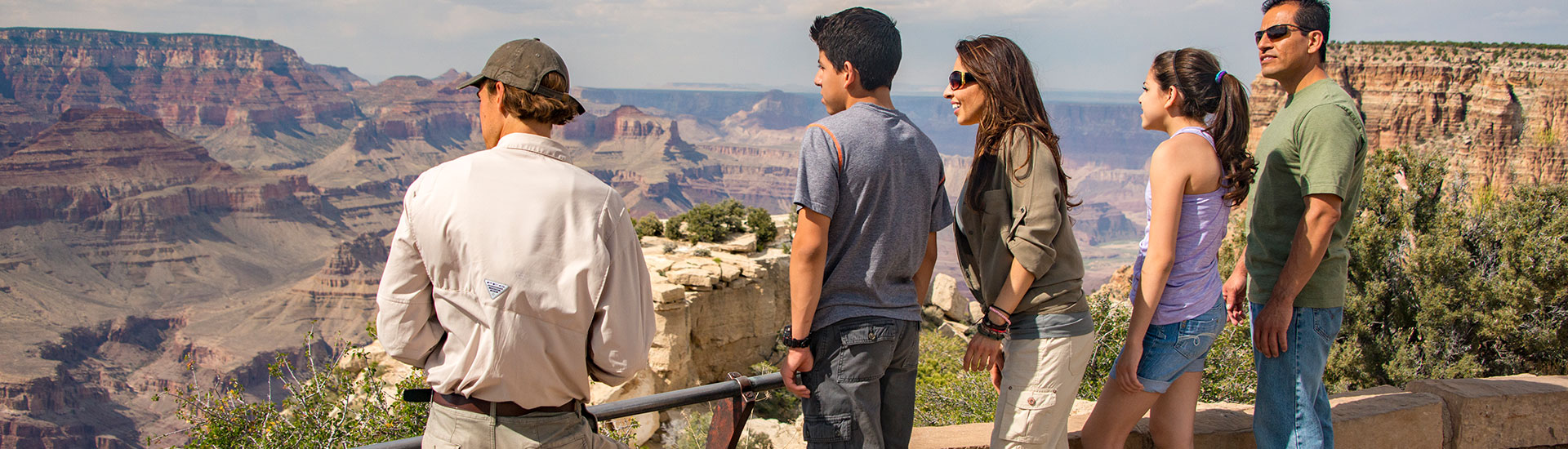 Pink Jeep Tours Grand Canyon Tour Guide and family of four looking out over the  Grand Canyon South Rim.