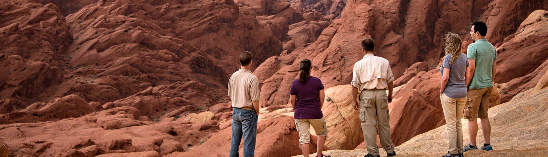 Pink Jeep Las Vegas tour guide and guests enjoying a close-up view of geological formations Valley of Fire State Park, NV.