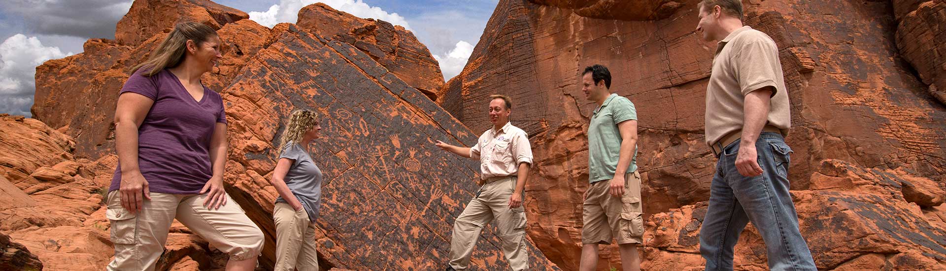 Pink Jeep Las Vegas adventure guide interpreting ancient rock art for guests while touring Valley of Fire State Park.