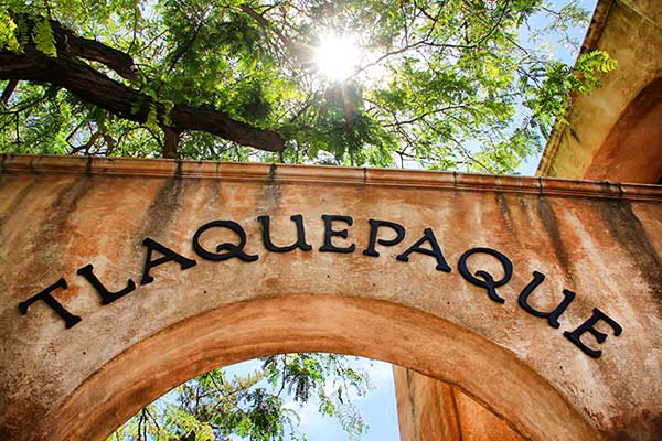 Sunbeam streaming through trees above arch at Tlaquepaque Arts & Crafts Village, Sedona, AZ.